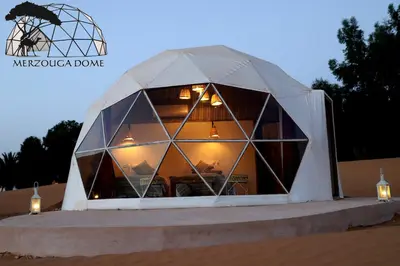 a igloo house in the desert with lights in it at Merzouga Dome in Merzouga