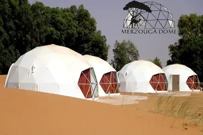 three domes in a desert with a sign that reads mexico dome at Merzouga Dome in Merzouga