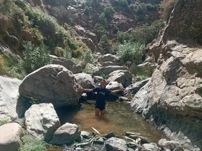 a man standing in a pool of water in a river at Gite Ain Bechar in Taza