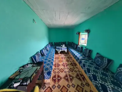 a room with a table and chairs in it at Gite Ain Bechar in Taza
