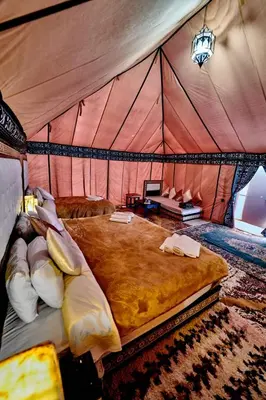 a bedroom with a large bed in a tent at Hamada Activities Luxury Camp in Merzouga