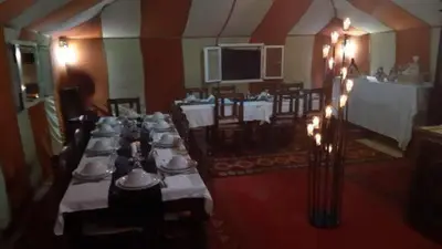 a large room with tables and chairs with lights at Hamada Activities Luxury Camp in Merzouga