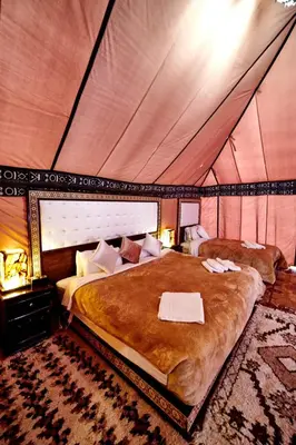 a bedroom with a large bed in a tent at Hamada Activities Luxury Camp in Merzouga