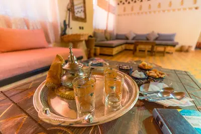 a table with a tray of food and glasses on it at Riad Ouzina TGM in Ouzina
