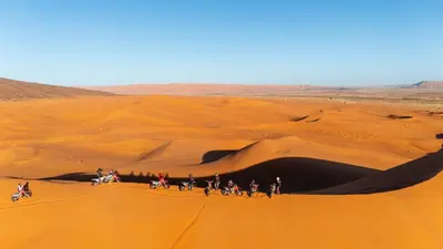 a group of people riding horses in the desert at Riad Ouzina TGM in Ouzina