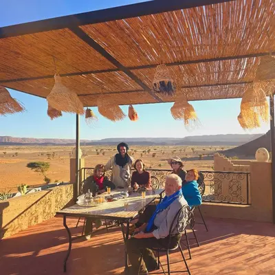 a group of people sitting at a table with a view at Riad Ouzina TGM in Ouzina