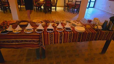 a table with food and plates of food on it at Riad Ouzina TGM in Ouzina