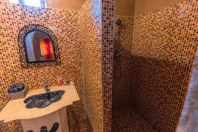 a bathroom with a sink and a mirror at Riad Ouzina TGM in Ouzina