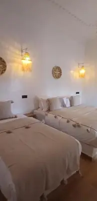 two beds and a couch in a room at Zagora Oasis Lodge & Desert Excursions in Zagora