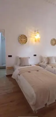 a white bedroom with a large bed and two couches at Zagora Oasis Lodge & Desert Excursions in Zagora