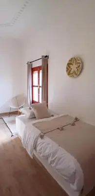 a white bedroom with a large bed and a window at Zagora Oasis Lodge & Desert Excursions in Zagora