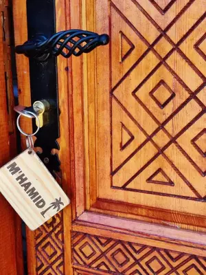 a lock on a wooden door with a key at Zagora Oasis Lodge & Desert Excursions in Zagora