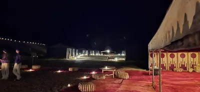 a person standing in front of a building at night at Erg Chigaga Torza Camp - Desert Glamping in El Gouera