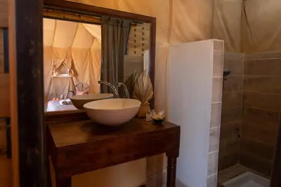 a bathroom with a bowl sink and a mirror at Erg Chigaga Torza Camp - Desert Glamping in El Gouera