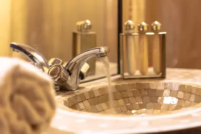 a bathroom sink with water coming out of a faucet at Erg Chigaga Torza Camp - Desert Glamping in El Gouera