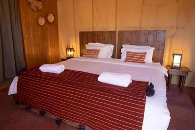 a large bed with two towels on top of it at Erg chegaga Daya Luxury Camp - Sahara Desert Stay in Mhamid