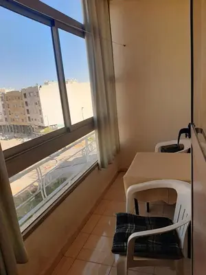 a room with a table and a large window at Charmant appartement à louer à meknès in Meknès