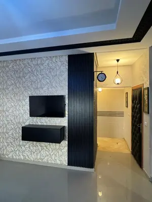 a living room with a television on a wall at Apprt in Fès
