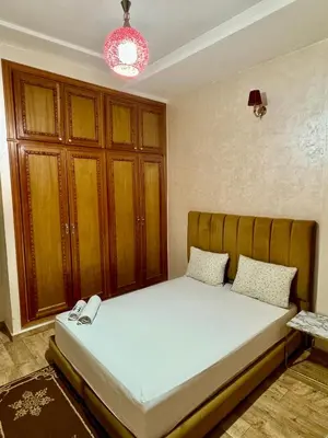 a bedroom with a bed with a wooden cabinet at Apprt in Fès