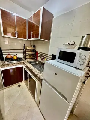 a kitchen with a white refrigerator and a microwave at Apprt in Fès