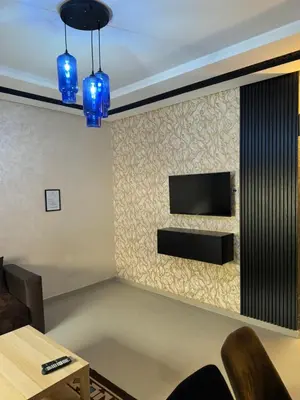 a living room with a tv on a wall with blue lights at Apprt in Fès