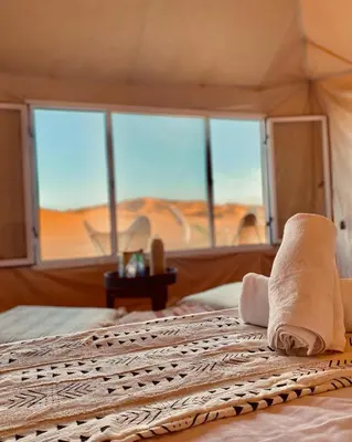 a hotel room with a bed with towels on it at Bohem Camp in Merzouga