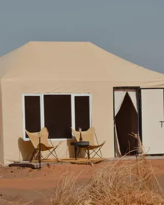 a white tent with chairs and a table in it at Bohem Camp in Merzouga