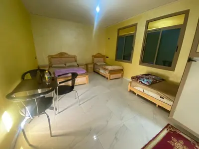 a room with two beds and a desk in it at Hotel Sotchi in Outat Oulad el Hajj