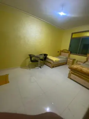 a room with two beds and a table in it at Hotel Sotchi in Outat Oulad el Hajj