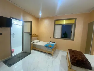 a small room with a bed and a mirror at Hotel Sotchi in Outat Oulad el Hajj
