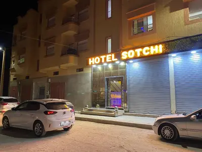 two cars parked in front of a hotel room at Hotel Sotchi in Outat Oulad el Hajj