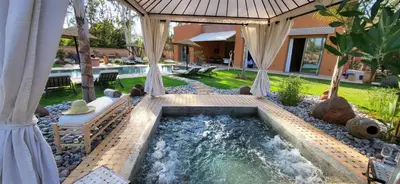 a swimming pool in a backyard with aitating at Le Jardin de Jeanne in Marrakech