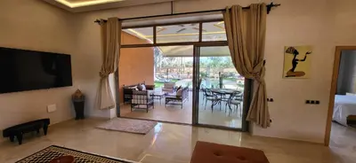 a living room with a large sliding glass door to a patio at Le Jardin de Jeanne in Marrakech
