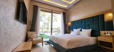 a bedroom with a large bed with a large window at Le Jardin de Jeanne in Marrakech