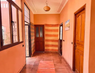 a hallway with orange walls and a wooden door at Family villa with swimming pool and a wonderful mountain view Family Only in Marrakech