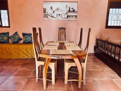 a wooden table and chairs in a room at Family villa with swimming pool and a wonderful mountain view Family Only in Marrakech