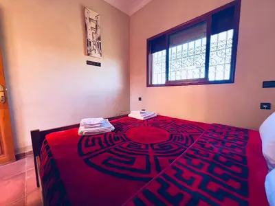a room with a bed with a red blanket and a window at Family villa with swimming pool and a wonderful mountain view Family Only in Marrakech