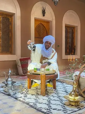 a man sitting on a table in a room at Riad Dar Susan - Authentic Stay in Zagora in Zagora