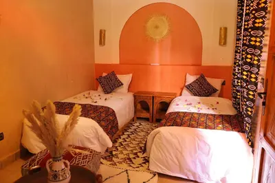 a room with two beds and a table at Riad Dar Susan - Authentic Stay in Zagora in Zagora