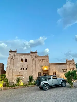 a gray jeep parked in front of a building at Riad Dar Susan - Authentic Stay in Zagora in Zagora
