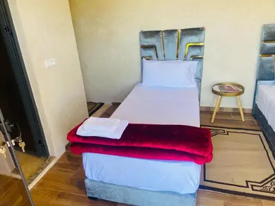a bedroom with a bed with a red blanket on it at villa ezzaouak in Marrakech