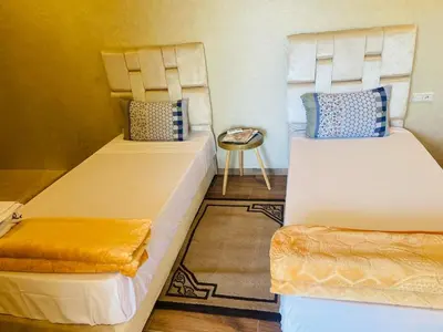 two beds in a small room with a table at villa ezzaouak in Marrakech