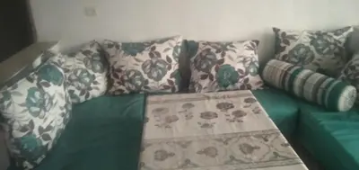 a green and white couch with pillows on it at شقة في البادية الهدوء والطبيعة نواحي فاس مكناس in Fès