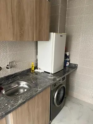 a small kitchen with a sink and a refrigerator at Appartement à marjane in Meknès