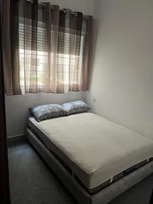 a small bed in a room with a window at Appartement à marjane in Meknès