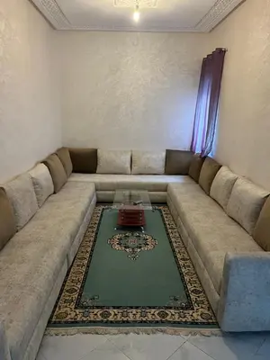 a living room with a large couch with a table at Appartement à marjane in Meknès