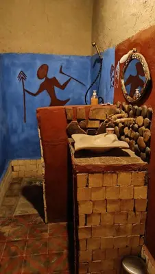 a bathroom with a brick wall and a mirror at kasbah luna del sur in Erfoud