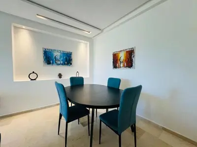 a dining room with a table and blue chairs at Paradise Prestigia Fes City Center sur Parc in Fès