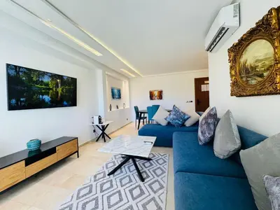 a living room with a blue couch and a table at Paradise Prestigia Fes City Center sur Parc in Fès
