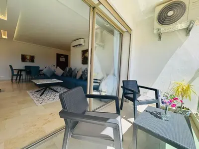 a living room with chairs and a blue couch at Paradise Prestigia Fes City Center sur Parc in Fès